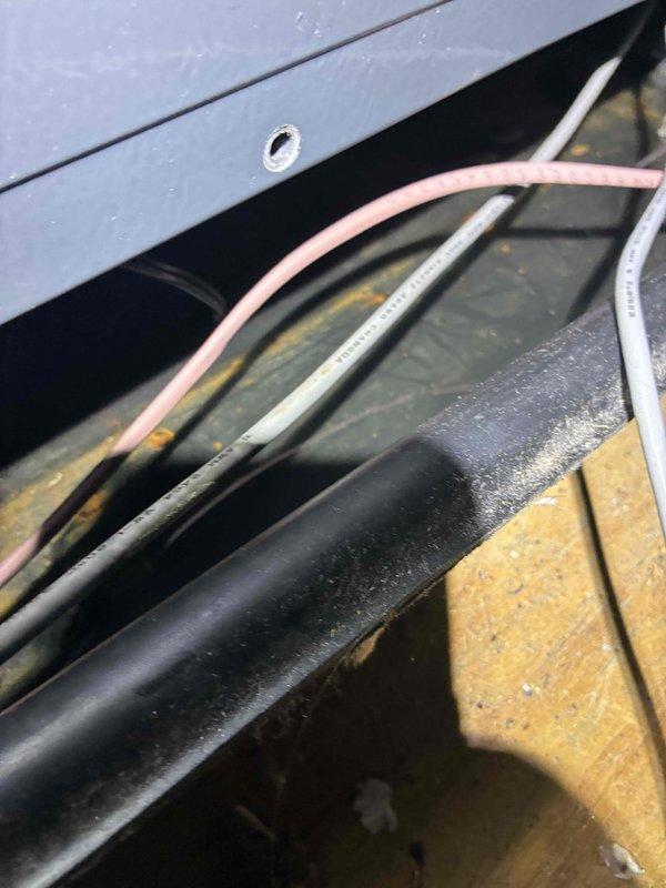 Responded to service call for air conditioning unit leaking from attic installation into second floor bedroom. Upon inspection, examined attic-mounted HVAC system and documented equipment condition, including condensate drainage components, insulated refrigerant lines, and electrical connections. Photographed affected areas showing mechanical equipment installation, wiring configuration, and insulation condition to assess potential leak sources and recommend appropriate repairs.