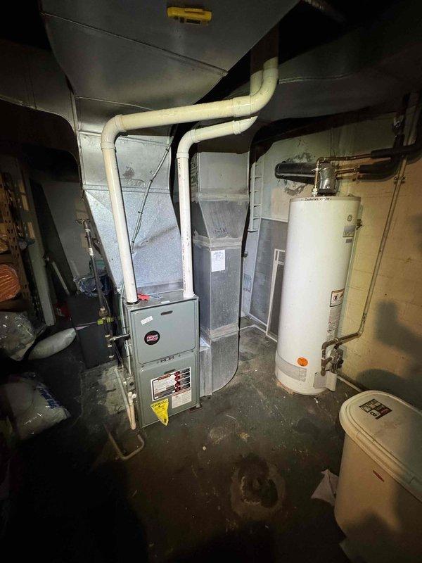 Completed scheduled preventive maintenance on aging residential cooling system as part of ongoing maintenance program. Performed comprehensive inspection of Lennox HVAC unit in basement mechanical room, including filter evaluation, electrical connections verification, and condensate drain line assessment. Documented equipment condition through photographic records showing furnace unit, associated PVC condensate piping, and surrounding mechanical systems including water heater and dehumidifier unit in utility space.