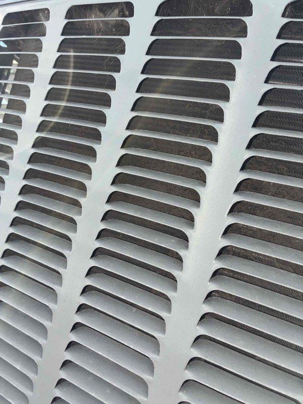 Completed comprehensive cooling system maintenance on HVAC unit. Inspected and photographed return air vent grilles, noting accumulated dust and debris within louvers and slat openings. System operational and performing within normal parameters following standard maintenance protocol.