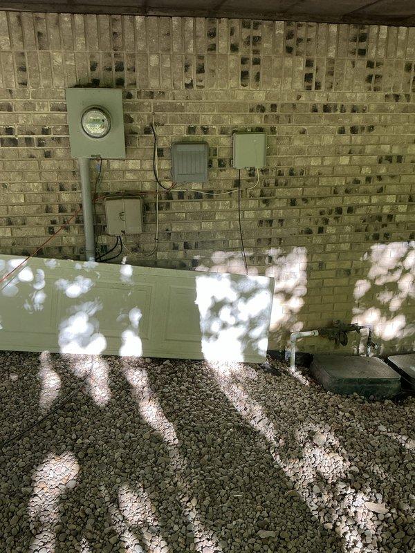 Conducted comprehensive site evaluation for generator installation at residential property. Assessed existing electrical infrastructure including current meter location, panel positioning, and available conduit pathways along exterior brick wall. Documented structural considerations for generator placement, evaluating clearance requirements under covered area with adequate ventilation through existing brick venting system. Examined grounding options and determined optimal routing for electrical connections from proposed generator location to main service panel. Photographed existing electrical equipment configuration and available installation space to develop accurate material list and labor requirements for permanent standby generator system installation.