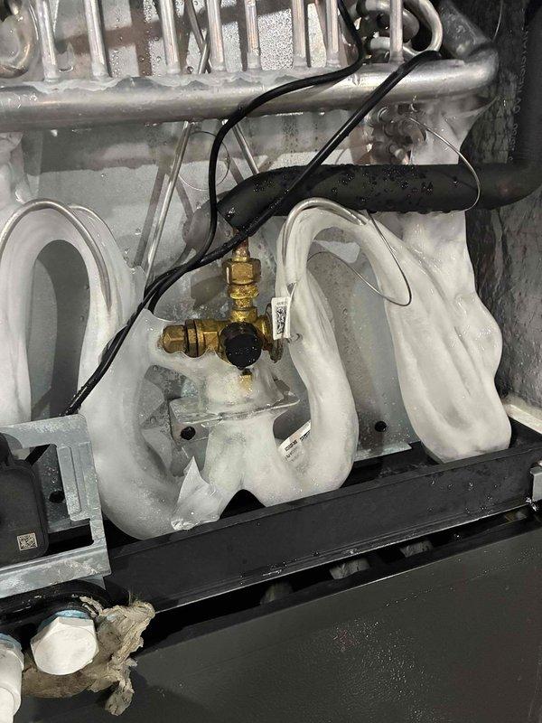 Performed routine heating system maintenance and inspection. Upon arrival, discovered significant water accumulation on concrete floor surrounding HVAC equipment, indicating active condensate drainage issue from heating unit. Inspected internal heating components including heat exchanger coils, condensate piping system, brass valve connections, and electrical wiring. Documented extensive water damage and staining on floor surface requiring attention to prevent equipment corrosion and potential system failure. System operational at time of inspection but condensate management requires follow-up repair to address drainage problems.