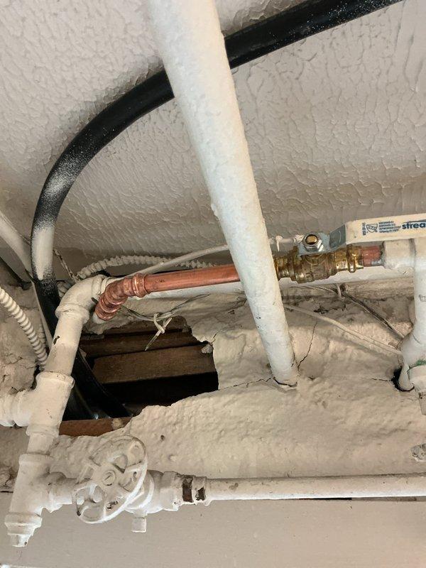 Responded to report of valve leaking in basement. Upon arrival, found extensive frost and ice buildup on plumbing infrastructure, indicating significant moisture exposure and freezing conditions affecting multiple pipes and valve assemblies. Inspected copper piping, PVC connections, and decorative shutoff valves in crawl space area with foam insulation. The frost accumulation on pipes, valve handles, and insulation material confirmed active leak combined with cold temperature conditions. Assessed brass fittings and connection points where copper transitions to PVC piping. Documented conditions showing ice crystallization on all exposed surfaces including pipe insulation wraps and valve components. Identified compromised areas requiring attention to prevent further water damage and potential pipe freezing issues.