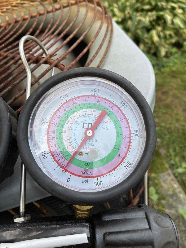 Responded to no cooling complaint on residential air conditioning system. Upon arrival, connected manifold gauges to assess refrigerant pressures and system operation. Diagnostic testing revealed abnormal pressure readings indicating potential refrigerant charge issue or system malfunction. Inspected outdoor condensing unit and noted significant rust and corrosion on fan guard, suggesting extended exposure to weather elements and potential maintenance concerns. Documented system pressures using calibrated gauges compatible with multiple refrigerant types including R-22 and R-410A. Performed visual inspection of copper coil assembly showing normal weathering patterns consistent with outdoor installation. System evaluation completed with photographic documentation of pressure readings and equipment condition for service records.
