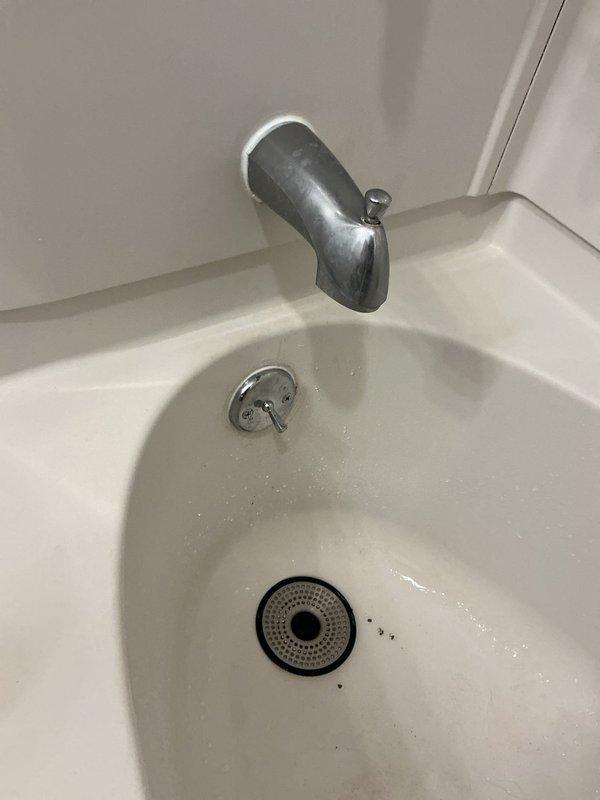 Replaced bathtub drain and overflow assembly with new chrome-finished components. Removed old deteriorated drain waste piping beneath fixture and installed new PVC drain assembly to ensure proper drainage and prevent future leaks.