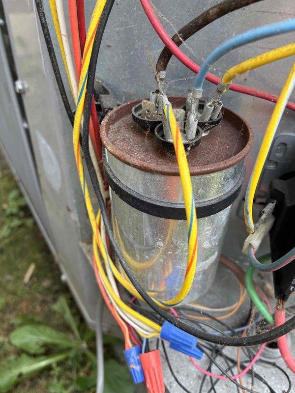 Completed comprehensive HVAC cooling system tune-up on outdoor condensing unit. Performed detailed inspection of electrical components, including capacitor assessment which showed significant rust and corrosion on housing and terminals. Utilized digital multimeter with clamp meter to verify electrical readings and system performance parameters. All connections tested and system operational upon completion.