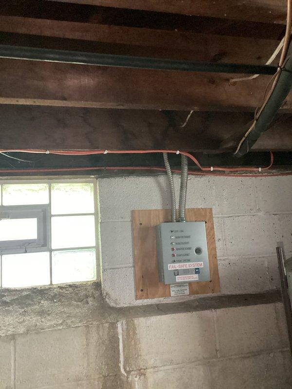 Responded to service call for mini split system displaying red indicator light. Customer reported unit had never been operated since installation, with air discharging from top of unit rather than bottom louvers, and both blue and red lights illuminating. Upon arrival, conducted visual inspection of indoor and outdoor components. Issue was identified during pre-occupancy inspection process. Documented installation deficiencies including unsecured refrigerant line sets requiring proper stapling per code requirements and loose sheet metal fasteners on ductwork connections. Photographed electrical panel installation and exposed mechanical systems in basement area showing bundled wiring routes through ceiling joists and refrigerant lines. Findings will be submitted to permit department to address inspector's noted deficiencies before final approval can be granted.