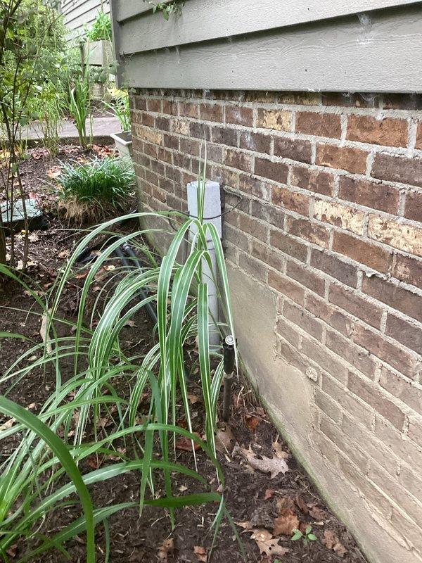 Conducted on-site electrical estimate for generator installation at residential property. Assessed existing gas meter location and foundation area to determine optimal placement and connection points for standby generator system. Documented current utility infrastructure including gas service entry point with weathered connections and available space along exterior wall with brick foundation and landscaped perimeter for equipment positioning and required clearances.