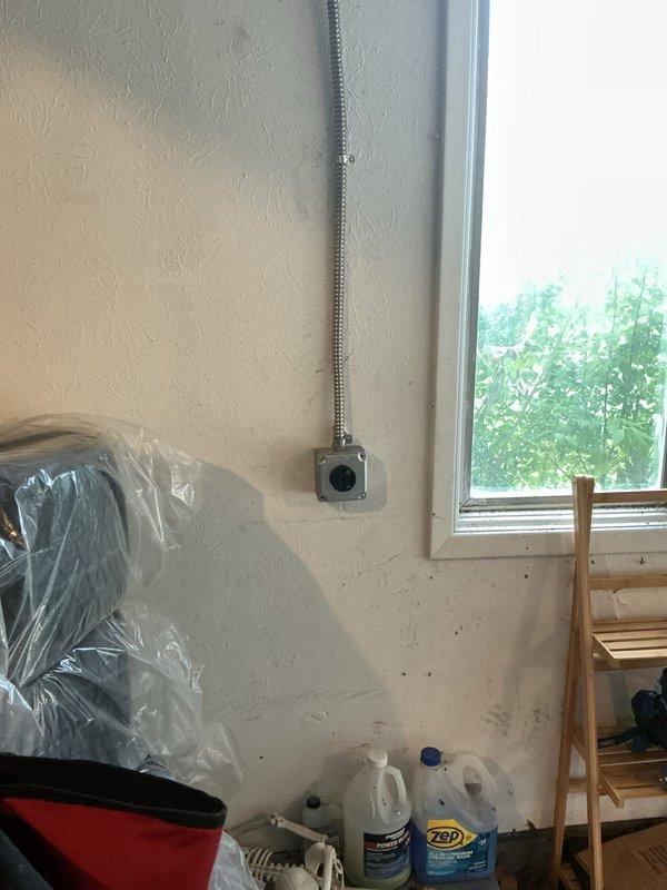 Installed a dedicated 240-volt, 60-amp circuit for electric vehicle charging at existing GE electrical panel in garage. Modified panel with tandem breakers to accommodate new circuit breaker, then ran flexible metal conduit along west wall to new 240-volt outlet location. Additionally installed complimentary whole home surge protector at main panel. Recommended future service upgrade to 200 amps if additional EV charger or major electrical appliances are planned.