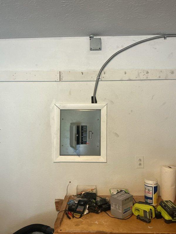 Installed a dedicated 240-volt, 60-amp circuit for electric vehicle charging at existing GE electrical panel in garage. Modified panel with tandem breakers to accommodate new circuit breaker, then ran flexible metal conduit along west wall to new 240-volt outlet location. Additionally installed complimentary whole home surge protector at main panel. Recommended future service upgrade to 200 amps if additional EV charger or major electrical appliances are planned.