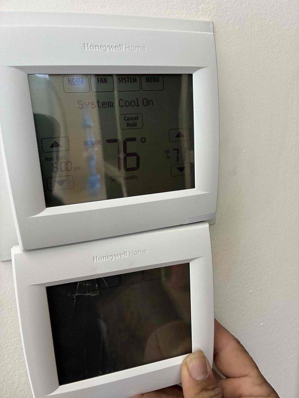 Responded to service call for cracked thermostat that was previously replaced. Removed damaged Honeywell Home digital thermostat unit and installed new replacement unit on existing wall mount. Verified proper system operation with cooling mode engaged, confirmed accurate temperature display reading 72°F, and tested all control functions including temperature adjustment arrows, system settings, and programmable features. System operating normally upon completion.