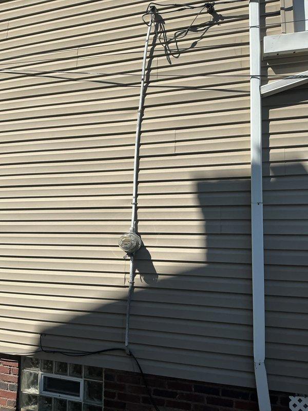 Conducted comprehensive electrical system assessment for grounding outlet installation estimate. Evaluated existing service entrance equipment, including exterior meter base and weatherhead configuration, and inspected main electrical panel to determine current circuit capacity and available spaces for potential GFCI or grounded circuit additions. Documented existing panel configuration with handwritten circuit labels identifying major appliances including A/C, dryer, range, and furnace circuits to assess compatibility with proposed grounding upgrades.