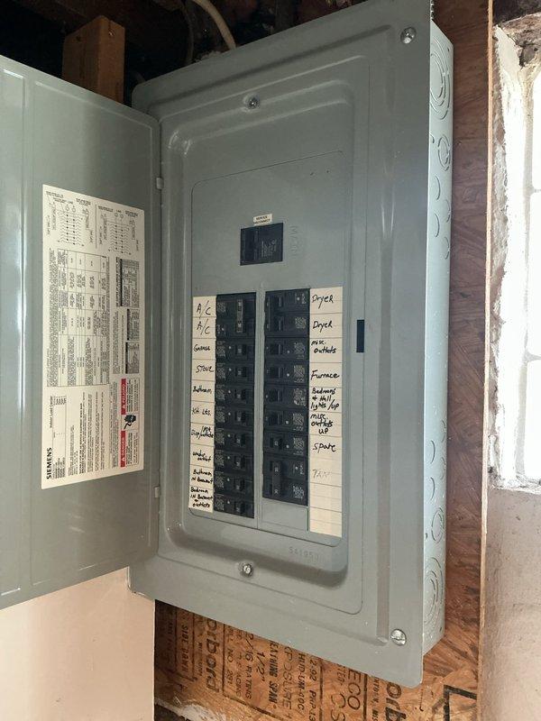 Conducted comprehensive electrical system assessment for grounding outlet installation estimate. Evaluated existing service entrance equipment, including exterior meter base and weatherhead configuration, and inspected main electrical panel to determine current circuit capacity and available spaces for potential GFCI or grounded circuit additions. Documented existing panel configuration with handwritten circuit labels identifying major appliances including A/C, dryer, range, and furnace circuits to assess compatibility with proposed grounding upgrades.