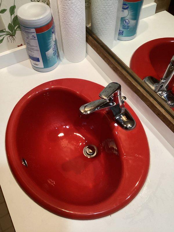 Completed installation of three Moen faucet assemblies in bathroom vanity setup, including one Moen Camerist single-handle faucet with spray feature and two Moen Chateau single-handle faucets. All units were mounted to white countertop with red ceramic basin sinks, with chrome finishes installed and drain assemblies connected. Tested all faucets for proper water flow, verified spray function operation, checked for leaks at supply connections and drain seals, and confirmed all fixtures were functioning correctly upon completion.