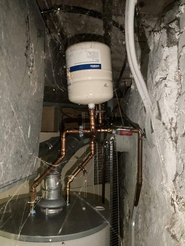Completed courtesy plumbing inspection of basement utility area. Documented existing hydronic heating system including expansion tank, copper piping distribution network, boiler unit, and heat exchanger components, with all equipment appearing properly connected and functional at time of inspection.