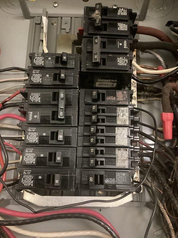 Performed courtesy electrical inspection and documented existing electrical panel conditions. Inspected main service panel containing Siemens components with multiple circuit breakers ranging from 15 to 20 amp ratings, verified wiring connections including red, black, white, and gray conductors, and photographed panel configuration showing standard residential installation with wire nuts, junction boxes, and main power feeds for customer records.