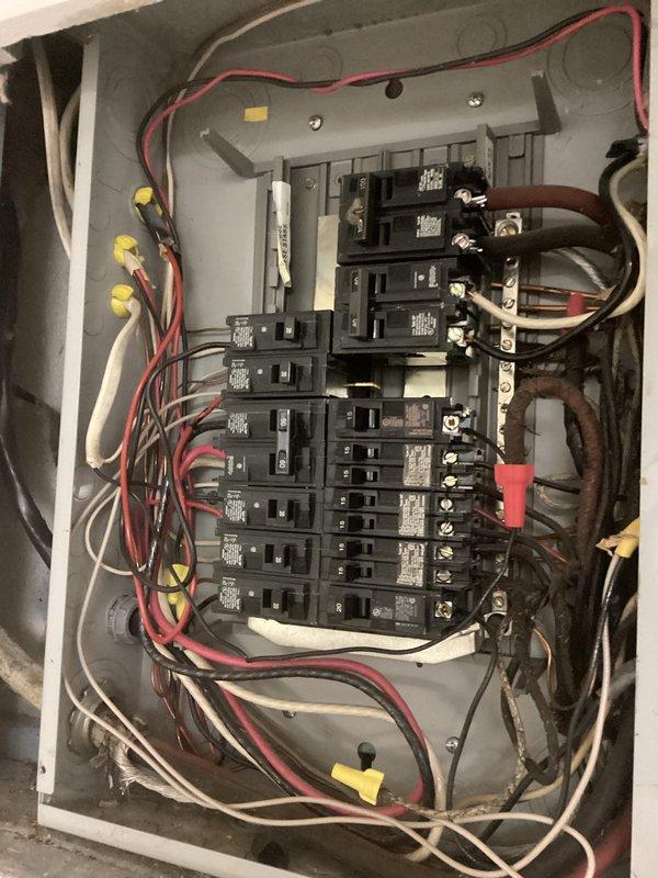 Performed courtesy electrical inspection and documented existing electrical panel conditions. Inspected main service panel containing Siemens components with multiple circuit breakers ranging from 15 to 20 amp ratings, verified wiring connections including red, black, white, and gray conductors, and photographed panel configuration showing standard residential installation with wire nuts, junction boxes, and main power feeds for customer records.