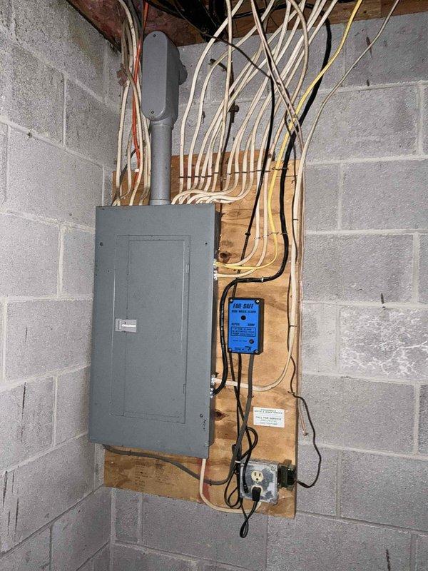 Conducted comprehensive site assessment for generator installation and electrical requirements to support existing forced air HVAC system. Evaluated current electrical panel configuration, conduit routing, and distribution setup in utility space. Photographed existing electrical infrastructure including organized cable management system with multiple conductor runs and mounted control devices. Assessed HVAC furnace unit specifications and documented equipment ratings to determine proper generator sizing and transfer switch requirements for backup power integration.