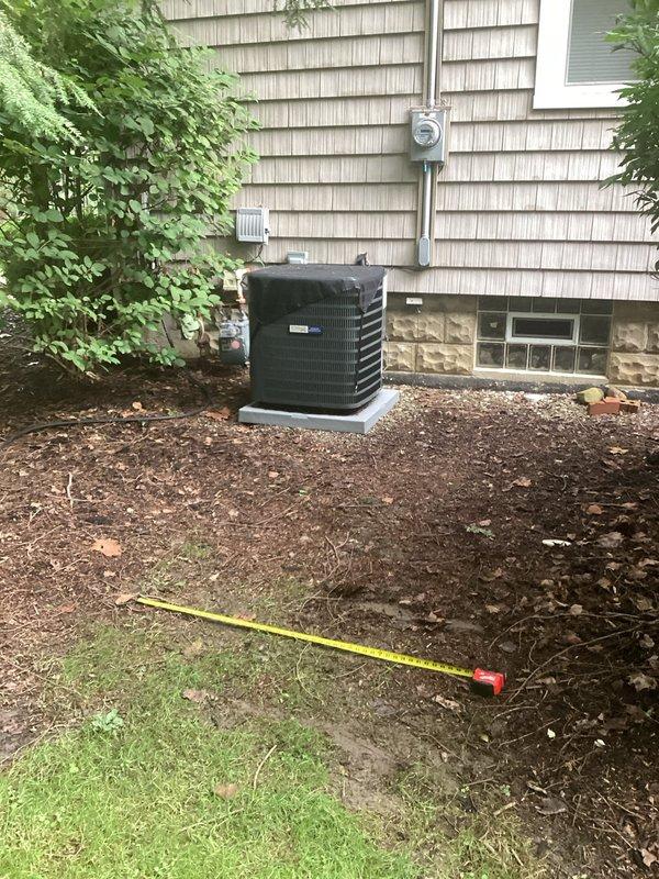Conducted comprehensive electrical assessment for residential generator installation at single-family home with existing HVAC infrastructure. Evaluated current electrical service capacity, meter location, and optimal routing path for generator supply conduit along exterior wall with tan wood shingle siding. Documented site conditions including existing AC unit placement on concrete pad, available space in mulched landscaping bed for generator positioning, and measured distances for electrical run from main service panel to proposed generator location, ensuring compliance with NEC clearance requirements from structure and HVAC equipment.
