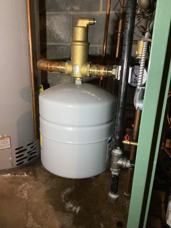 Completed scheduled heating system tune-up and maintenance inspection on boiler and hot water heater. Performed diagnostic testing with digital meter showing heat exchanger temperature at 37.6°F, inspected expansion tank, brass valve assembly, and copper piping connections throughout the mechanical room. Documented water staining and discoloration on concrete floor around equipment base to address customer's concern regarding dampness around units; recommended monitoring for potential leaks in plumbing connections or condensate drainage issues.