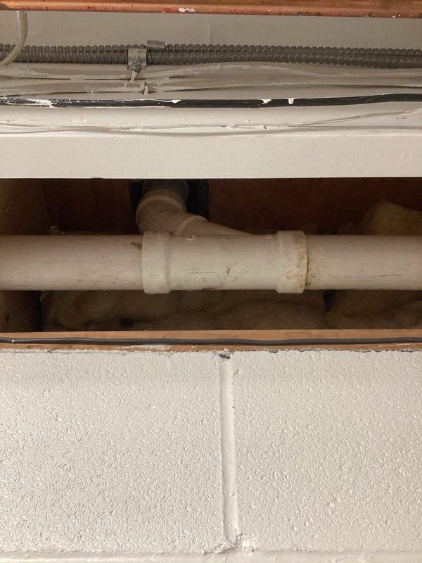 Responded to emergency no-water call at 1989-construction residence with failed original plumbing infrastructure. Inspected main water shutoff valve in basement and identified severely corroded brass valve with compromised seating and aged copper supply line showing significant oxidation. Documented existing PVC distribution piping with access point through interior wall cavity, revealing aged coupling connections. Due to emergency nature of complete water loss, prioritized immediate assessment and coordinated with customer regarding urgency of restoration timeline and available repair options for failed main shutoff assembly.
