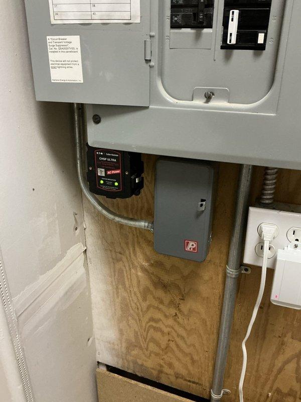 Provided comprehensive electrical estimate for backup generator installation at residential property. Assessment included evaluation of existing electrical service panel configuration, available mounting space on plywood backing board, and outdoor generator placement location. Documented current electrical infrastructure including main service panel, secondary breaker panel, surge protection device, and conduit routing to determine integration requirements for automatic transfer switch and generator connection. Evaluated exterior installation site conditions including concrete pad deterioration, existing utility penetrations, and weathered foundation area to specify proper generator mounting, fuel line routing, and weatherproofing requirements for safe and code-compliant installation.