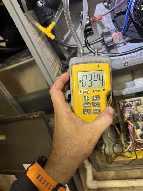 Responded to no heat call and performed diagnostic testing on furnace system. Upon inspection, utilized digital manometer to measure pressure readings within the HVAC unit, which indicated abnormal values. Further investigation revealed issues with the control board, where visual inspection showed a displaced blue electrolytic capacitor and potential component failure on the PCB. Diagnosed control board malfunction as the root cause of heating system failure and documented findings with diagnostic measurements and circuit board condition for repair recommendations.