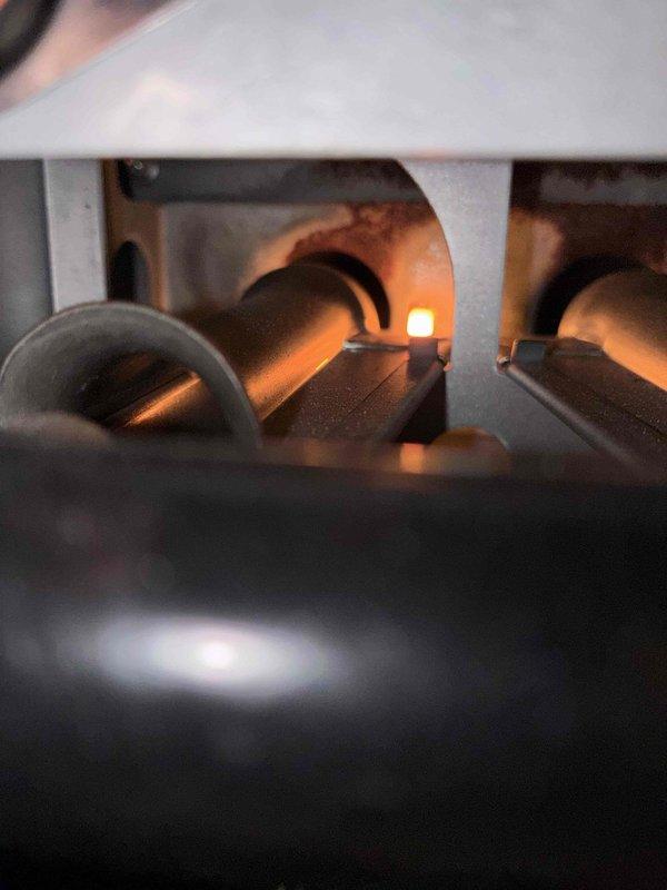 # HVAC Heating Maintenance Service

Completed routine heating maintenance on gas furnace as part of ongoing service plan. Inspected heat exchanger and burner assembly, noting significant rust and corrosion on heat exchanger chambers with active blue flames present at burner ports indicating proper combustion. Documented system condition with photos showing deteriorated metal surfaces and operational burner assembly for maintenance records and future reference.