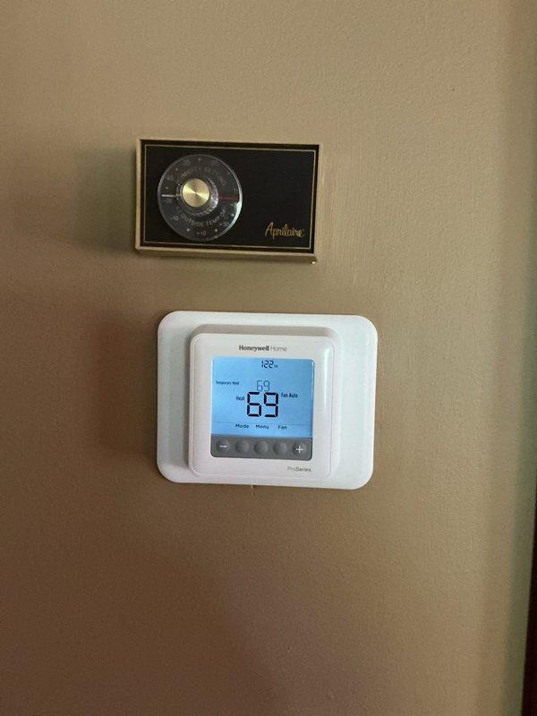Responded to service call for malfunctioning thermostat. Upon arrival, found older Aprilaire analog thermostat installed above newer Honeywell Home ProSeries digital thermostat displaying erratic temperature reading of 89 degrees. Diagnosed faulty thermostat operation and replaced with properly functioning Honeywell Home ProSeries unit. Verified new thermostat displaying accurate temperature of 69 degrees and confirmed proper communication with furnace system. System tested and operational.