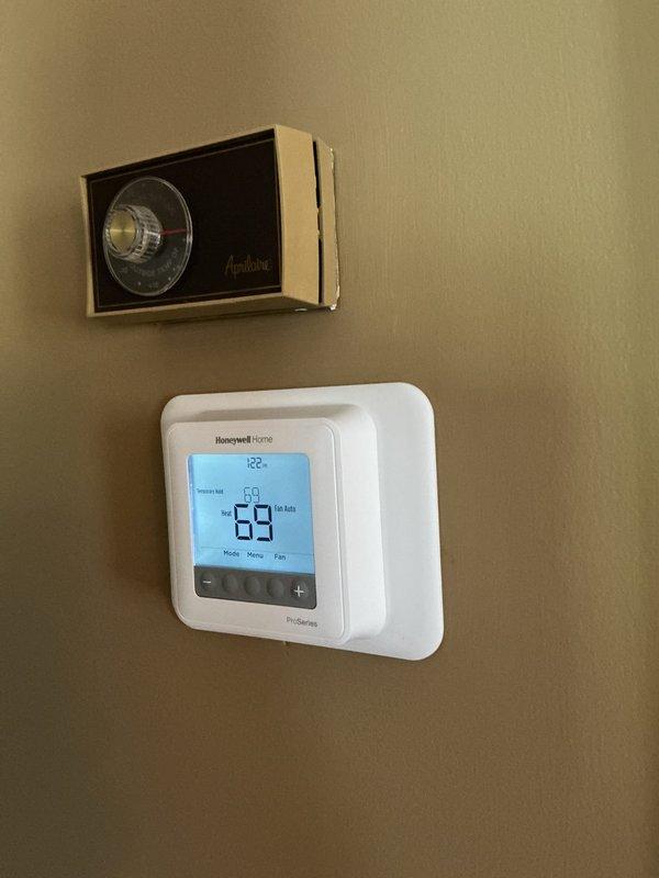Responded to service call for malfunctioning thermostat. Upon arrival, found older Aprilaire analog thermostat installed above newer Honeywell Home ProSeries digital thermostat displaying erratic temperature reading of 89 degrees. Diagnosed faulty thermostat operation and replaced with properly functioning Honeywell Home ProSeries unit. Verified new thermostat displaying accurate temperature of 69 degrees and confirmed proper communication with furnace system. System tested and operational.