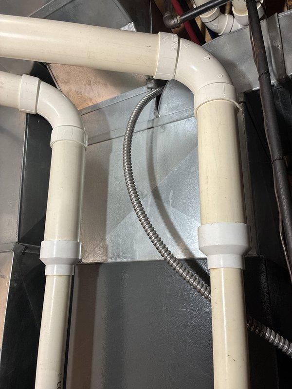 Conducted comprehensive assessment of residential HVAC system for complete replacement estimate following maintenance cost concerns with existing furnace and air conditioning equipment. Evaluated outdoor condensing unit positioned along exterior wall and inspected interior mechanical components including ductwork, PVC drainage system, and flexible conduit connections. Documented existing system configuration and infrastructure to provide accurate replacement recommendations for complete heating and cooling system upgrade.