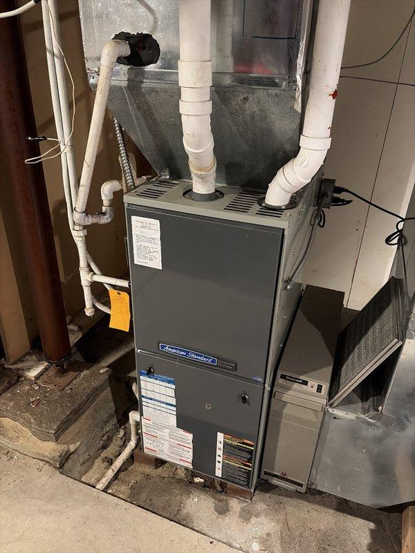 Completed scheduled heating maintenance on American Standard furnace system. Performed comprehensive inspection of unit including burner assembly, heat exchanger, blower motor, and all safety controls. Verified proper operation of gas valve and ignition system. Inspected and confirmed integrity of PVC venting system with dual intake and exhaust pipes. Measured supply air temperature at register reading 122.5°F, indicating proper heat rise and system performance. Checked all electrical connections, tested thermostat operation, and verified adequate airflow through ductwork. Inspected condensate drainage system and confirmed proper function. Unit operating within manufacturer specifications with no issues identified.