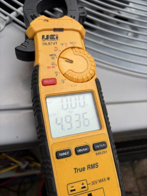 Completed comprehensive HVAC heating and cooling tune-up service on residential system. Performed electrical diagnostics using clamp meter, recording voltage readings of 100.0V and amperage of 4936mA to verify proper system operation. Inspected and tested dual-run capacitor rated at 10µF/370VAC, confirmed secure terminal connections with blue and yellow lead wires, and verified contactor functionality. All components operating within manufacturer specifications with no deficiencies noted.
