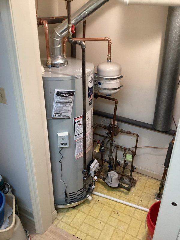 Replaced existing 40-gallon short water heater with new unit including all necessary code upgrades. Installation included mounting new water heater on wooden platform with proper clearances, installing icon System gas control valve with electronic ignition, connecting temperature and pressure relief valve with discharge piping, and configuring complete copper supply and distribution piping system with shutoff valves. Added expansion tank to plumbing system for thermal expansion management and pressure regulation. Completed all gas line connections, installed PVC condensate drainage system at base of unit, and ensured proper venting configuration. All work performed to current plumbing and building code standards with upgraded safety features and control systems.