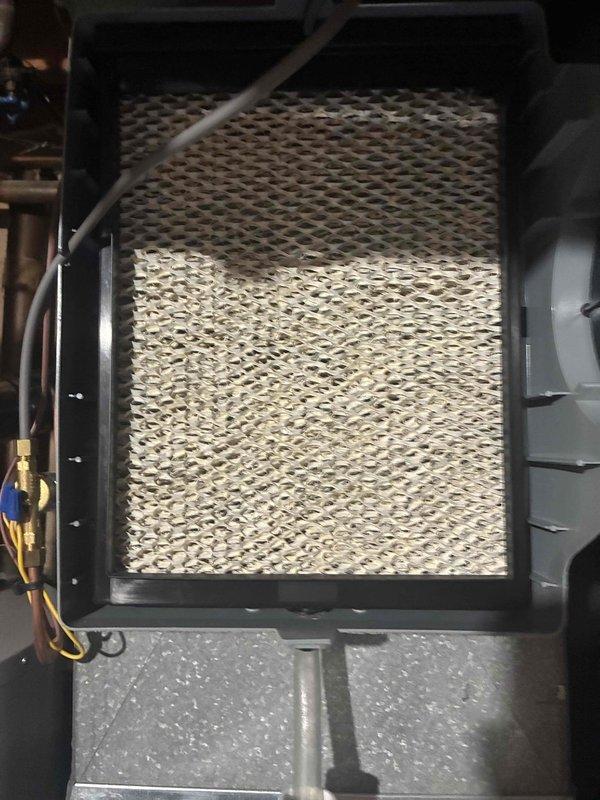 Completed comprehensive cooling system maintenance on HVAC unit. Inspected evaporator coil and filter assembly, which showed moderate dust accumulation in upper section requiring attention. Verified system operation with supply air temperature reading of 18.3°F, confirming proper refrigerant charge and cooling performance. Checked refrigerant line connections and humidifier control panel for proper operation.