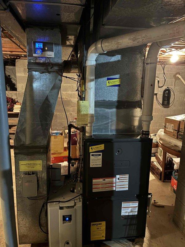 # HVAC Heating Maintenance Summary

Completed scheduled preventive heating maintenance on residential furnace system as part of ongoing recurring service plan. Performed comprehensive inspection of furnace unit, ductwork connections, and associated air handling components. Documented system condition through interior and exterior equipment photography, noting oxidation staining present in ductwork base and minor dust accumulation throughout enclosure. Verified proper operation of digital control system and confirmed all safety labels and manufacturer specifications remain visible and intact. All equipment functioning within normal parameters at time of service completion.