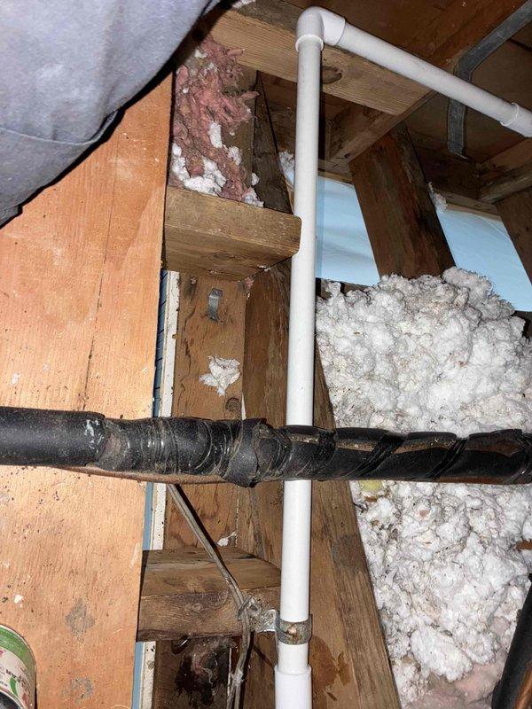 Reinstalled and rerouted PVC condensate drain line in attic space. Replaced existing drain piping with new white PVC pipe, ensuring proper pitch and secure connections throughout the run. Repositioned drain line between ceiling joists for improved drainage flow and to prevent future backup issues. Verified all pipe joints are sealed and tested system for proper operation.