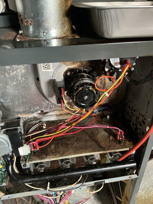 Responded to service call for 27-year-old American Standard furnace with reported sensor malfunction. Upon arrival, conducted comprehensive system inspection and diagnostic testing. Found extensive rust and corrosion on galvanized ductwork connections and significant debris accumulation throughout blower compartment, indicating prolonged lack of maintenance. Tested all electrical components and wiring connections, including control board and blower motor assembly. Identified faulty sensor and replaced defective component. Cleaned blower compartment and removed accumulated rust debris from internal surfaces. Verified proper condensate drainage system operation and inspected PVC drain lines for blockages. Tested all safety controls and limit switches for proper operation. Cycled furnace through multiple heating cycles to confirm sensor functionality and verify proper system operation. All components now operating within manufacturer specifications. Documented internal conditions with pho