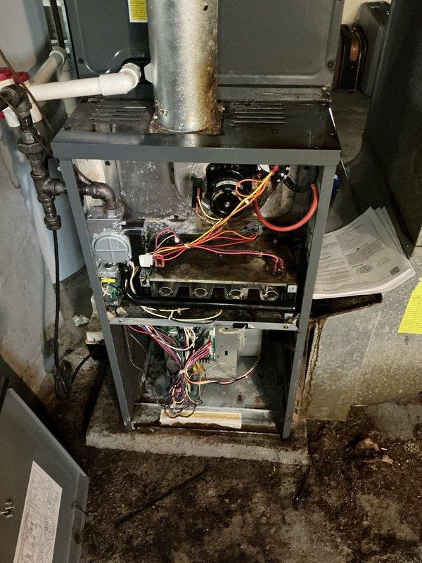 Responded to service call for 27-year-old American Standard furnace with reported sensor malfunction. Upon arrival, conducted comprehensive system inspection and diagnostic testing. Found extensive rust and corrosion on galvanized ductwork connections and significant debris accumulation throughout blower compartment, indicating prolonged lack of maintenance. Tested all electrical components and wiring connections, including control board and blower motor assembly. Identified faulty sensor and replaced defective component. Cleaned blower compartment and removed accumulated rust debris from internal surfaces. Verified proper condensate drainage system operation and inspected PVC drain lines for blockages. Tested all safety controls and limit switches for proper operation. Cycled furnace through multiple heating cycles to confirm sensor functionality and verify proper system operation. All components now operating within manufacturer specifications. Documented internal conditions with pho