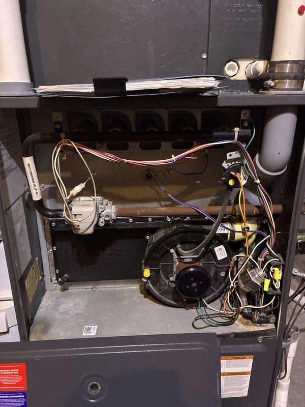 Conducted comprehensive HVAC system evaluation for full replacement estimate at residential property accessed via garage entry. Documented existing gas furnace installation showing heat exchanger, blower motor assembly, gas valve components, and associated electrical wiring harnesses. Photographed current system configuration including ductwork connections, PVC condensate drainage, refrigerant line sets with foam insulation, and mechanical room layout to provide homeowner with complete system replacement options and equipment specifications.