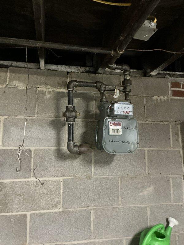 Conducted comprehensive site evaluation for Generac generator installation in residential basement utility area. Assessed existing gas meter infrastructure, electrical panel capacity, and available mounting locations. Documented current gas line configuration with black pipe connections and verified clearance requirements for generator placement. Evaluated electrical service panel conditions and determined integration points for automatic transfer switch installation. Photographed utility room layout including concrete block wall conditions, ceiling joist clearances, and workspace accessibility for equipment installation planning.