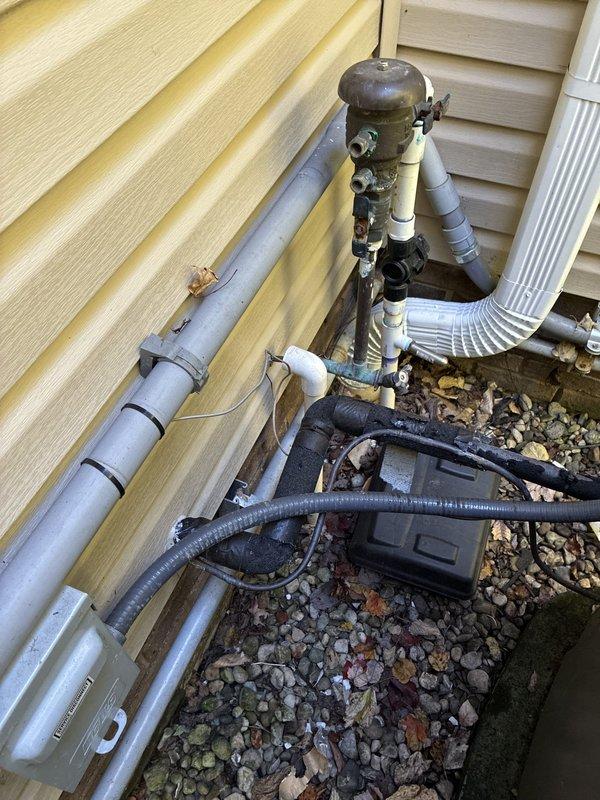 Conducted on-site evaluation to provide furnace replacement options for residential HVAC system. Documented existing exterior utility installations including heavily corroded condensate drainage components and deteriorating metal fittings requiring attention during equipment upgrade.