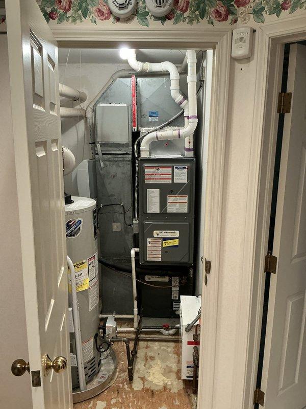 Completed HVAC estimate for furnace replacement in master bedroom utility closet. Assessed existing dark-colored furnace unit with associated water heater, copper plumbing assembly with motorized valve, and PVC ventilation system. Documented current equipment configuration including ductwork connections and provided replacement options for heating system upgrade. Completed HVAC estimate for furnace replacement in master bedroom utility closet. Assessed existing dark-colored furnace unit with associated water heater, copper plumbing assembly with motorized valve, and PVC ventilation system. Documented current equipment configuration including ductwork connections and provided replacement options for heating system upgrade.