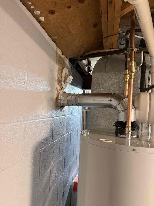 Completed installation of 50-gallon short Bradford White automatic storage natural gas water heater with expansion tank in basement utility room. Unit installed with proper copper piping connections, brass shutoff valves, code-compliant venting through masonry wall, and all safety labels visible per manufacturer specifications. Completed installation of 50-gallon short Bradford White automatic storage natural gas water heater with expansion tank in basement utility room. Unit installed with proper copper piping connections, brass shutoff valves, code-compliant venting through masonry wall, and all safety labels visible per manufacturer specifications.