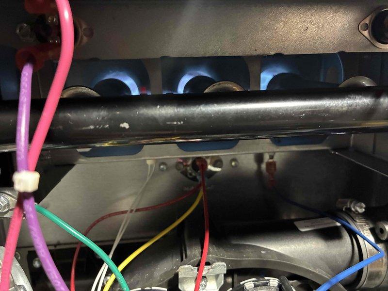 Completed scheduled heating maintenance visit on residential furnace system. Performed comprehensive inspection of burner assembly, confirmed proper ignition and flame characteristics with all burners operating efficiently and producing consistent blue flames. Verified electrical performance using digital clamp meter, measuring amperage draw and system voltage to ensure components are functioning within manufacturer specifications at 0.00A standby and 55.3°F temperature readings. Inspected burner chamber, heat exchanger access area, and all visible wiring connections for signs of wear or deterioration. System operating properly with no deficiencies noted at time of service.
