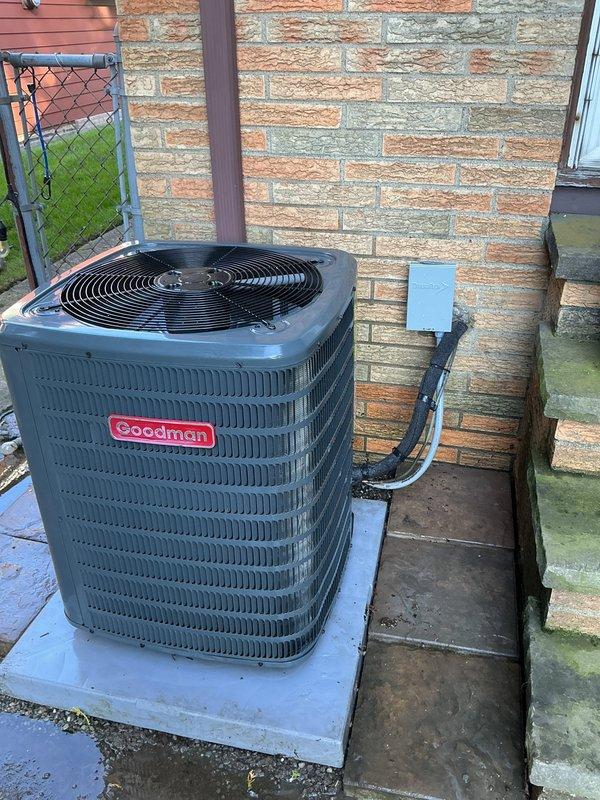 Performed a cooling system tune-up on a 1-year-old Goodman outdoor condenser, inspecting the unit, condenser coil, fan assembly, electrical disconnect, and pad. The system was found operating properly, with light dirt and debris buildup noted along the lower coil section and no frost, rust, or damage present. Inspected the pad perimeter where animal digging had disturbed the base and confirmed the unit remains level and stable, with gravel present around the pad. Performed a cooling system tune-up on a 1-year-old Goodman outdoor condenser, inspecting the unit, condenser coil, fan assembly, electrical disconnect, and pad. The system was found operating properly, with light dirt and debris buildup noted along the lower coil section and no frost, rust, or damage present. Inspected the pad perimeter where animal digging had disturbed the base and confirmed the unit remains level and stable, with gravel present around the pad.