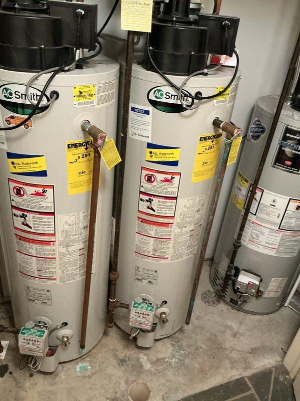 Chagrin Falls, OH - Performed scheduled maintenance inspection of a three-unit gas water heater bank supplying the heated flooring system, including a visual assessment of vent/blower assemblies, gas control valves, T&P relief valve piping, and supply/return connections. Identified green oxidation and corrosion staining on the copper piping and fittings of one unit, along with rust-colored joints on the ferrous interconnecting piping and residue near the base of an adjacent unit, indicating possible minor weeping at connections. Documented conditions with photographs for the service record and recommended continued monitoring and corrective repair of the affected fittings. Chagrin Falls, OH - Performed scheduled maintenance inspection of a three-unit gas water heater bank supplying the heated flooring system, including a visual assessment of vent/blower assemblies, gas control valves, T&P relief valve piping, and supply/return connections. Identified green oxidation and corrosion staining on the copper piping and fittings of one unit, along with rust-colored joints on the ferrous interconnecting piping and residue near the base of an adjacent unit, indicating possible minor weeping at connections. Documented conditions with photographs for the service record and recommended continued monitoring and corrective repair of the affected fittings.