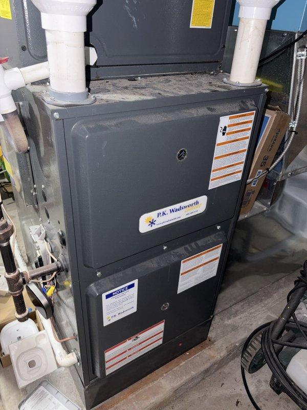 Performed scheduled heating maintenance on an upright gas furnace, including inspection of the cabinet, gas piping, PVC intake/exhaust venting, ductwork connections, and electrical conduit, with no signs of frost, ice, or significant rust observed. Removed and inspected the condensate drain trap assembly, noting damp staining and debris on the surrounding floor and drain area, and documented the unit's condition with photos. Performed scheduled heating maintenance on an upright gas furnace, including inspection of the cabinet, gas piping, PVC intake/exhaust venting, ductwork connections, and electrical conduit, with no signs of frost, ice, or significant rust observed. Removed and inspected the condensate drain trap assembly, noting damp staining and debris on the surrounding floor and drain area, and documented the unit's condition with photos.