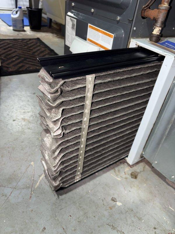 Performed scheduled heating maintenance on the furnace, replacing the heavily soiled pleated air filter that was loaded with dust and lint to restore proper airflow. Inspected the condensate drain and removed a small plastic component, likely the condensate trap or pressure switch assembly, for cleaning and evaluation. Noted corrosion on a pipe fitting at the equipment, which should be monitored for leaks. Performed scheduled heating maintenance on the furnace, replacing the heavily soiled pleated air filter that was loaded with dust and lint to restore proper airflow. Inspected the condensate drain and removed a small plastic component, likely the condensate trap or pressure switch assembly, for cleaning and evaluation. Noted corrosion on a pipe fitting at the equipment, which should be monitored for leaks.