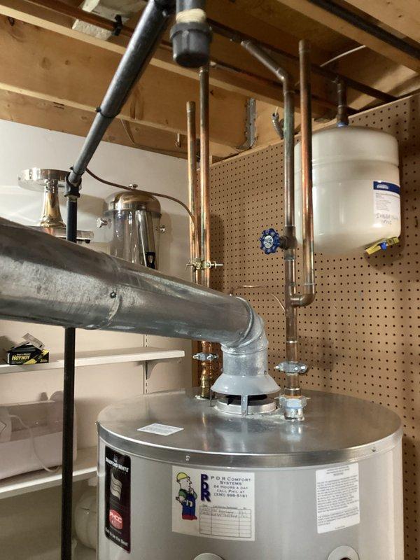 Performed service on a Bradford White gas tank-type water heater, inspecting the supply and outlet copper piping, shutoff valve, thermal expansion tank, gas supply with ball valve, and galvanized flue connection through the draft hood. All connections were found secure with no evidence of leaks, corrosion, or venting issues, and the unit was verified operational. Performed service on a Bradford White gas tank-type water heater, inspecting the supply and outlet copper piping, shutoff valve, thermal expansion tank, gas supply with ball valve, and galvanized flue connection through the draft hood. All connections were found secure with no evidence of leaks, corrosion, or venting issues, and the unit was verified operational.