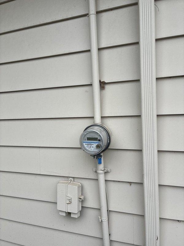 Performed an on-site evaluation for furnace replacement and presented equipment options. Inspected the exterior electrical service, including the utility meter, conduit, and junction box, and found no visible damage or corrosion. Inspected the existing unit's integrated control board and wiring harness within the cabinet, noting the board powered with its status indicator illuminated and the cabinet showing dust and light surface wear. Performed an on-site evaluation for furnace replacement and presented equipment options. Inspected the exterior electrical service, including the utility meter, conduit, and junction box, and found no visible damage or corrosion. Inspected the existing unit's integrated control board and wiring harness within the cabinet, noting the board powered with its status indicator illuminated and the cabinet showing dust and light surface wear.